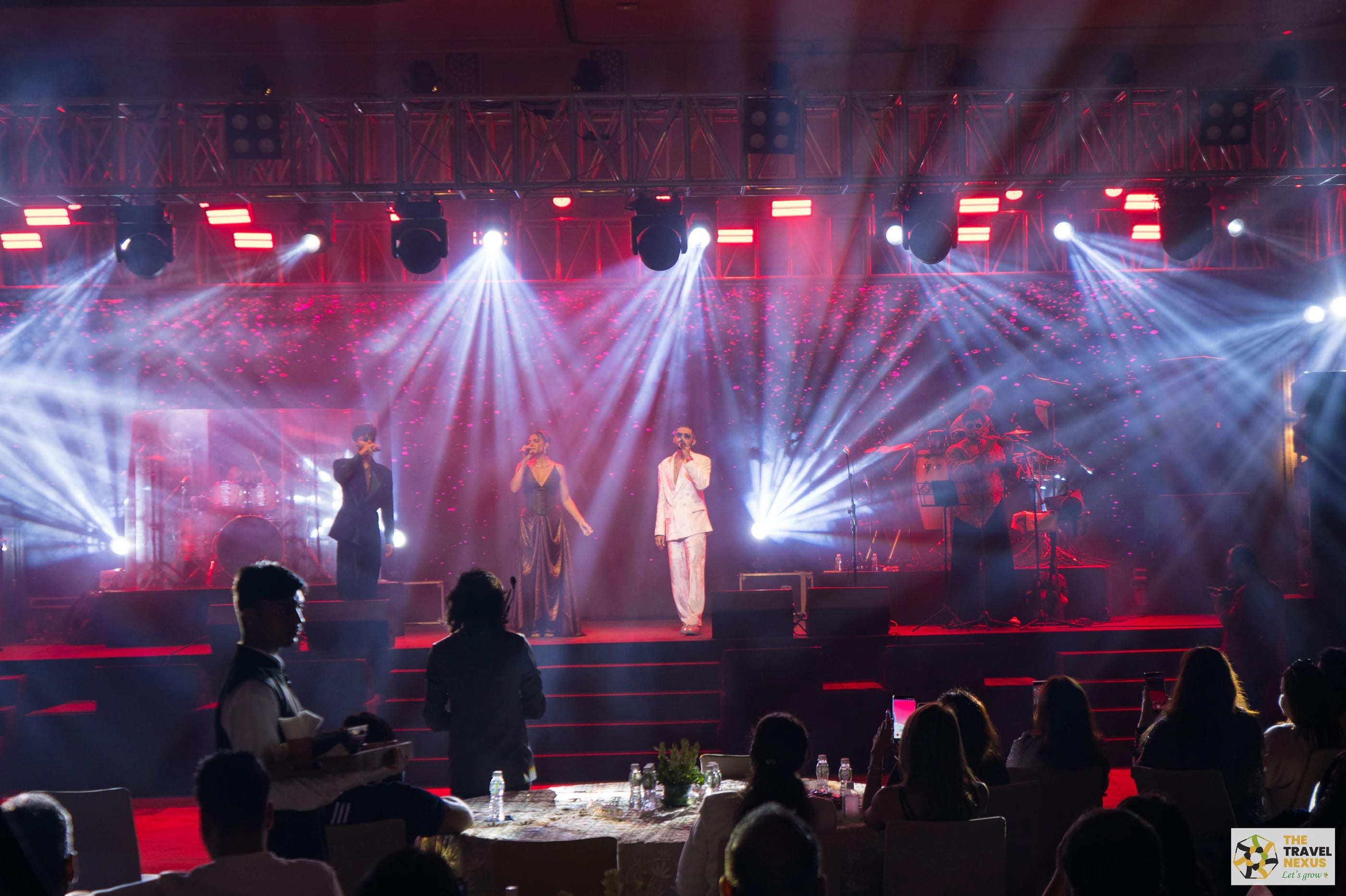Live performers on the Travel Nexus stage beneath concert lighting