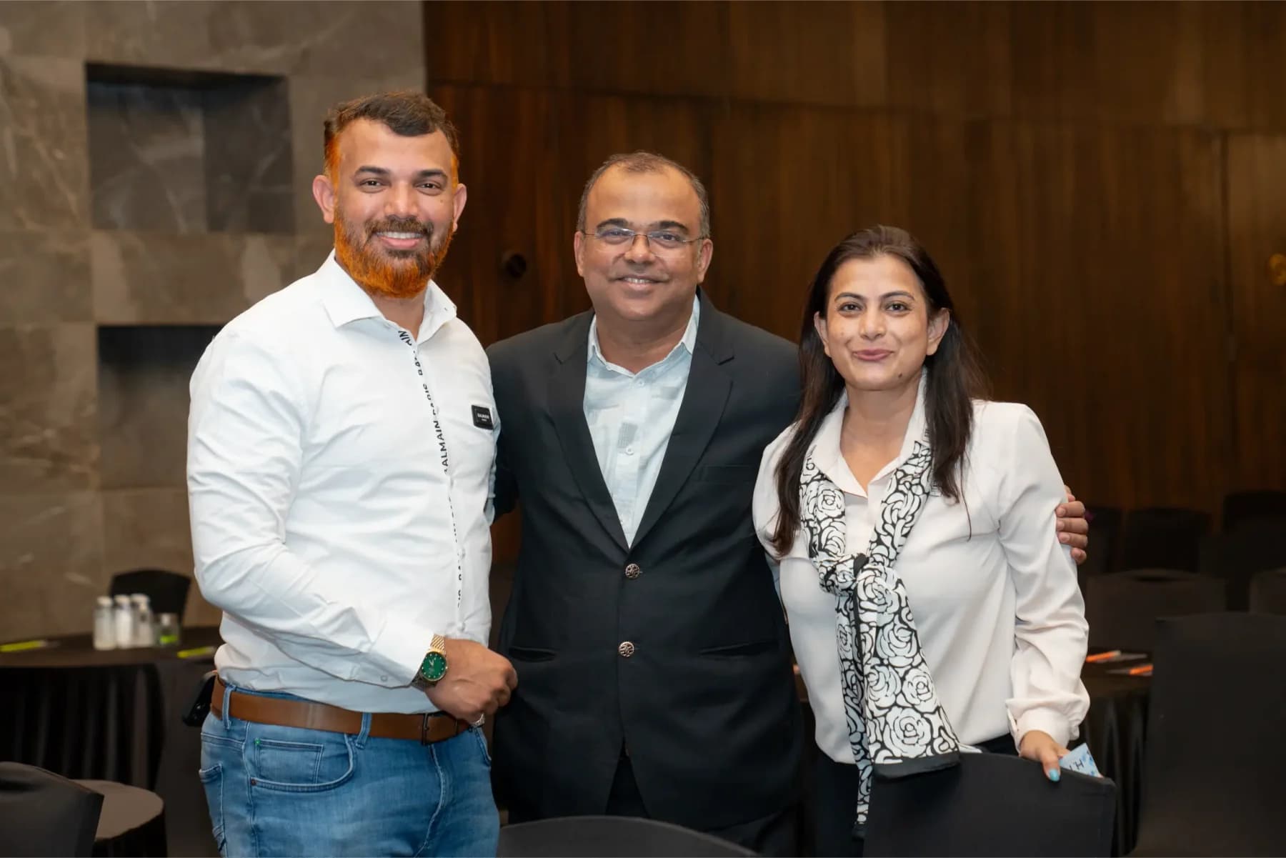 Three Travel Nexus members standing together and smiling at a members' meeting